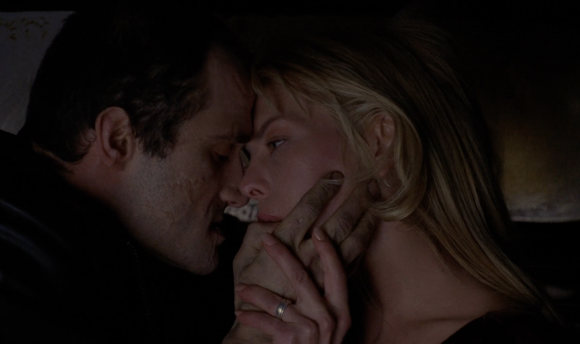 Vaughan cradles Catherine's (Deborah Kara Unger) face. His thumb is in her mouth.